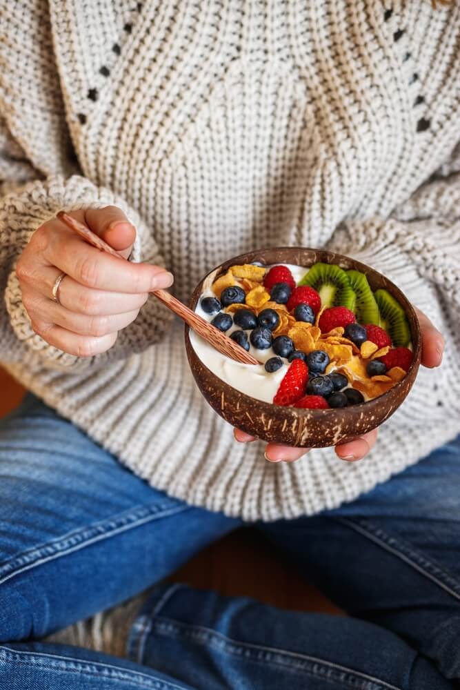 person eating fruit in a bowl